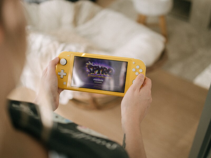 Je Nintendo Switch (hier afgebeeld), mobiel toestel of misschien zelfs laptop in de reiskoffer? Dan kan er worden gegamed tijdens je vakantie.