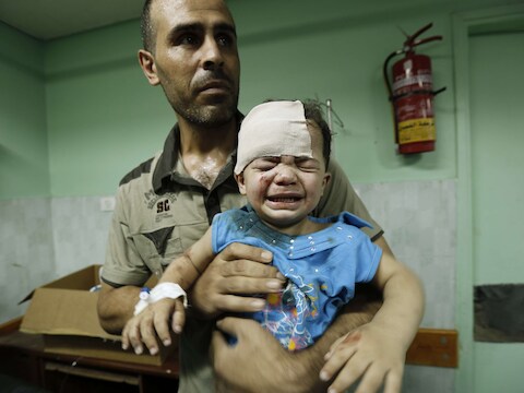 Een Palestijnse man met zijn kind, dat gewond raakte tijdens een Israëlische luchtaanval.