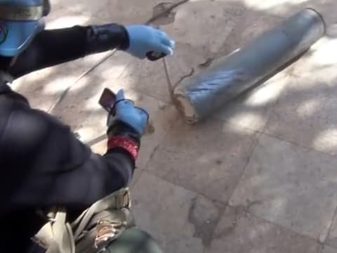 Screenshot van een YouTube-video waarop een inspecteur van de VN een bus onderzoekt die gifgas zou hebben bevat.