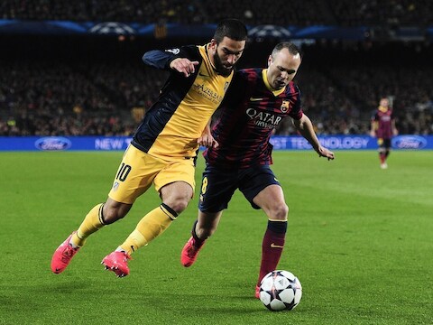 Arda Turan (links) in actie tegen Iniesta.