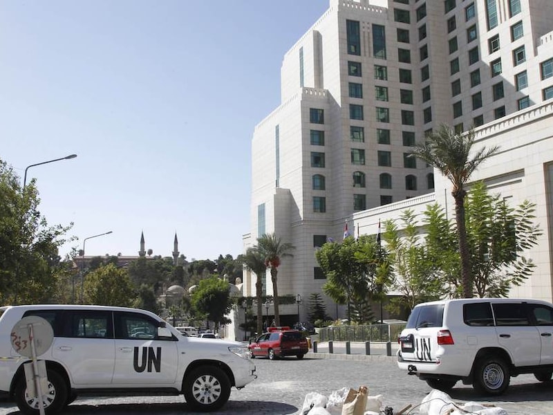 VN-wagens voor het Four Seasons-hotel in Damascus, waar een team van het OPCW toeziet op de vernietiging van het Syrische chemische wapenarsenaal.