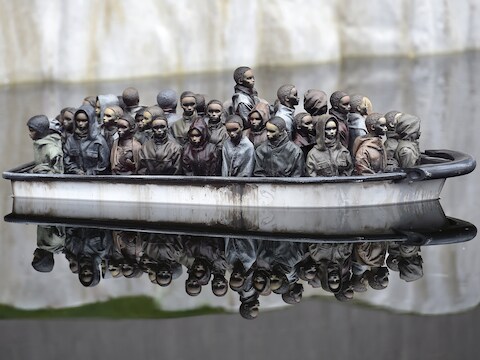 Bezoekers aan 'Dismaland' (Naargeestigland) kunnen miniatuurbootjes met vluchtelingen besturen.