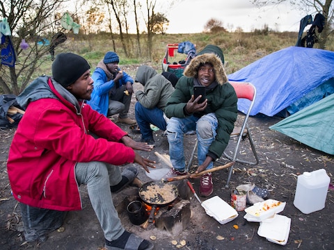 Vluchtelingen uit Soedan wachten bij hun tentjes bij Calais op een kans om Het Kanaal over te steken.
