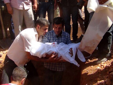De vader van Aylan draagt zijn zoontje ten grave in Kobane.