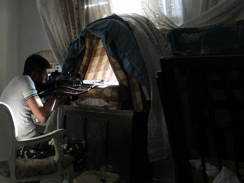 Een rebellenstrijder in Aleppo. Rebellen hebben mensen geëxecuteerd, in gijzeling genomen en burgers in woonwijken onder vuur genomen.