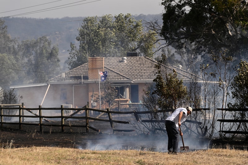 Un hombre está rodeado de tierra quemada en el pueblo de Longwood.