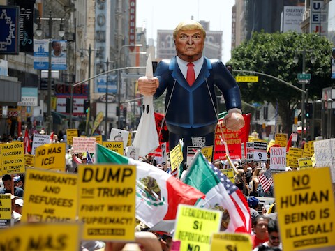 Een opblaasbare Donald Trump en tal van leuzen tijdens een protestmars in de straten van Los Angeles.