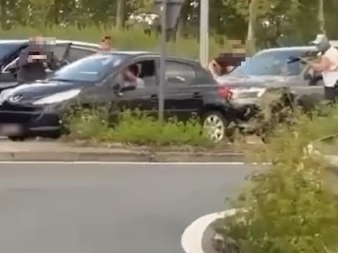Een beeld van de arrestatie. Gemaskerde agenten in burger houden de bestuurder van een Peugeot onder schot in de Merestraat in Aalst.