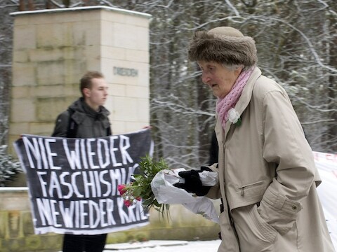 Mensen leggen bloemen neer op het kerkhof.