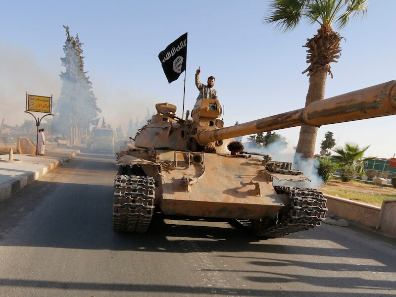 IS-strijders met een buitgemaakte tank in de Syrische stad Raqqa. Foto uit juni 2014.
