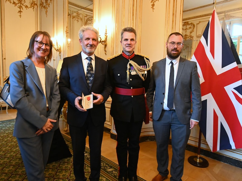 Geert Bekaert ontving de hoge onderscheiding op de Britse ambassade in Brussel. Ook schepen Joachim Jonckheere (rechts) was daarbij aanwezig. 