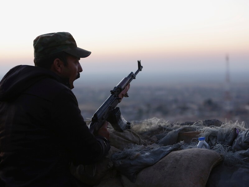 Een peshmerga-strijder kijkt uit over een gebied in Sinjar.
