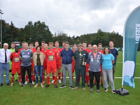 De spelers, het stads- en clubbestuur op het nieuwe kunstgrasveld van KFC Eksaarde.