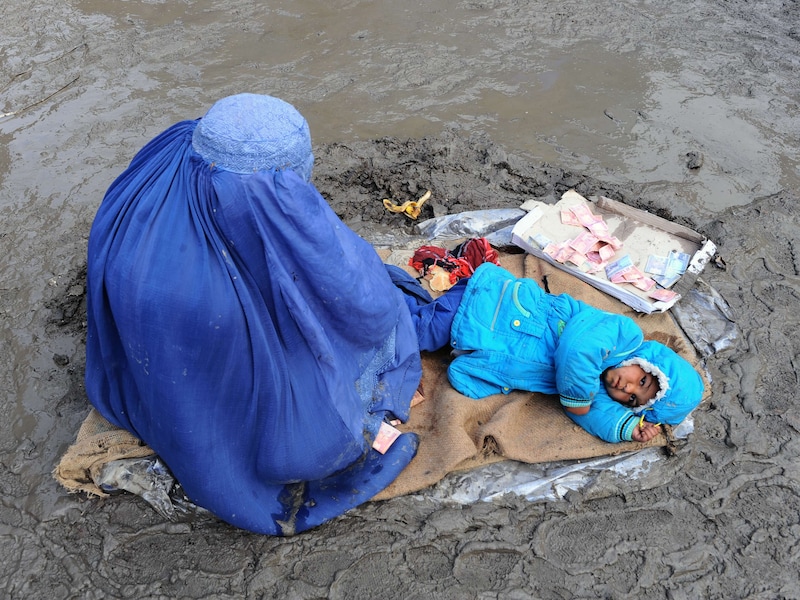 Eem Afghaanse vrouw en haar kind bedelen in Kabul om giften.