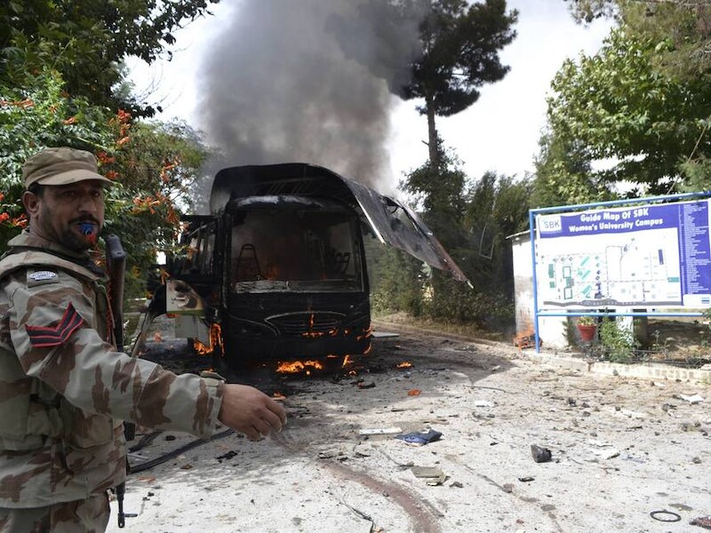 Een soldaat bij de brandende bus in Quetta.