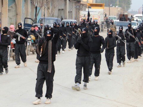 ISIL-strijders paraderen op 2 januari met hun wapens door de straten van de Syrische stad Tel Abyad, vlakbij de grens met Turkije.