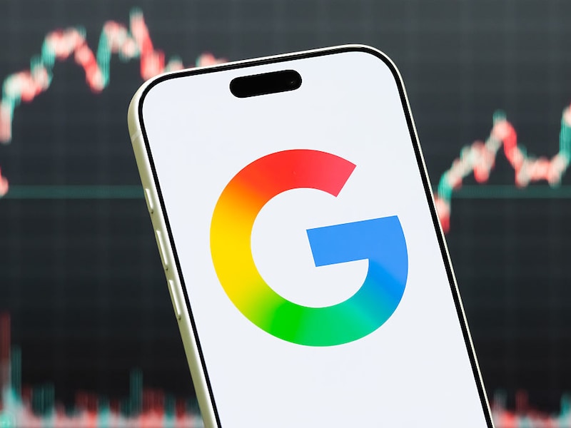 SHENZHEN, CHINA - JULY 19: In this photo illustration, a smartphone displays the logo of Google, a subsidiary of Alphabet Inc. (NASDAQ: GOOGL, GOOG) providing internet search, online advertising, cloud computing, software, artificial intelligence and consumer technology services, in front of a screen showing the company's latest stock market chart on July 19, 2026 in Shenzhen, Guangdong Province, China. (Photo illustration by Cheng Xin/Getty Images)