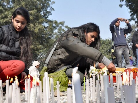 Indiase meisjes steken kaarsen aan ter nagedachtenis van de vrouw die de groepsverkrachting op een bus in New Delhi niet overleefde.