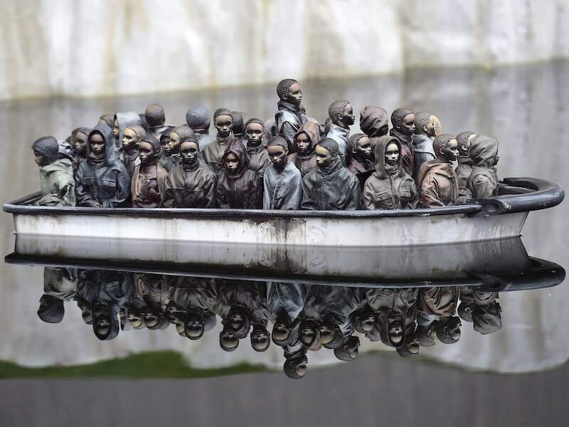 Bezoekers aan 'Dismaland' (Naargeestigland) kunnen miniatuurbootjes met vluchtelingen besturen.