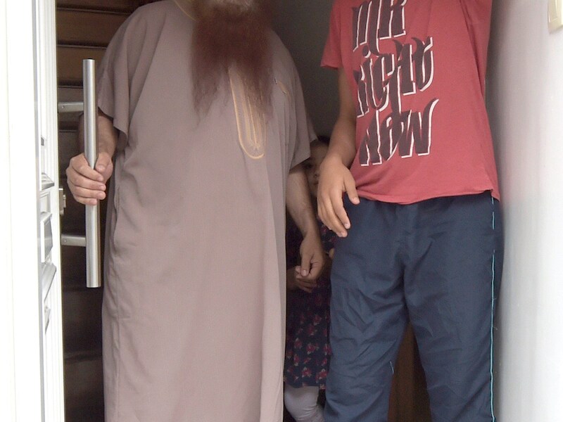 Imam Shayh Alami, die illegaal in het land verblijft, en zijn zoon.