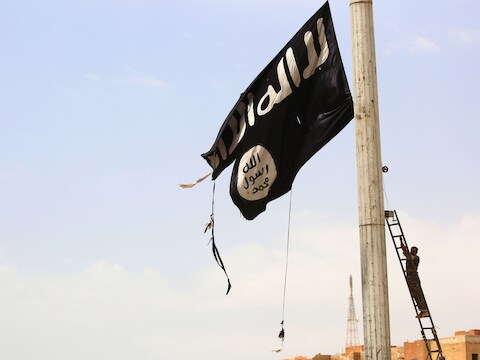 Een lid van een Koerdische verzetsgroep verwijdert in de heroverde Syrische stad Tabqa een vlag van Islamitische Staat.(Archieffoto 30 april)