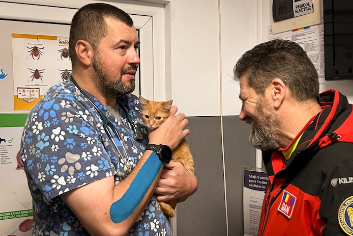 De dierenarts bespreekt de toestand van Perzik met Dan Benga, het hoofd van de Roemeense bergreddingsdienst.