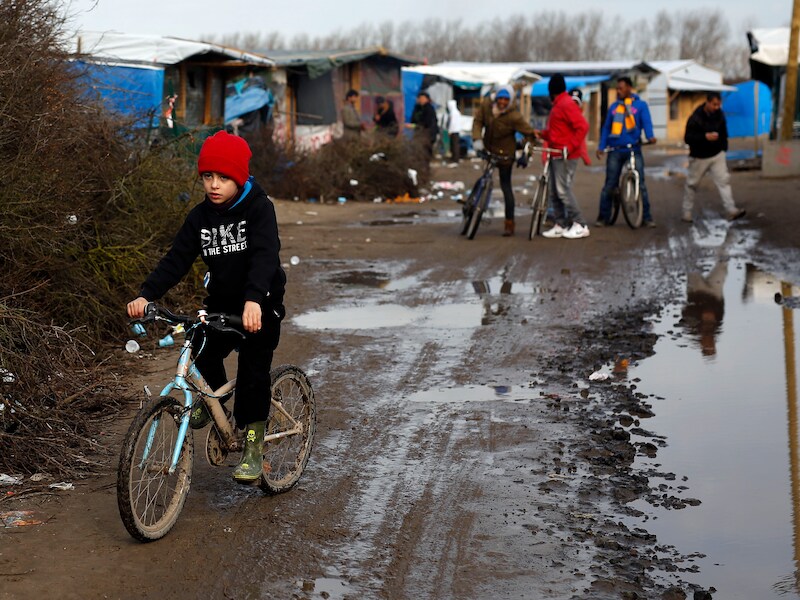 Kinderen fietsen in The Jungle van Calais.