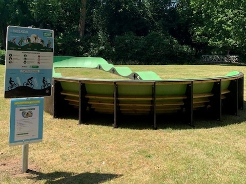 Een pumptrack is een ovalen piste met opeenvolgende hobbels en scherpe bochten.