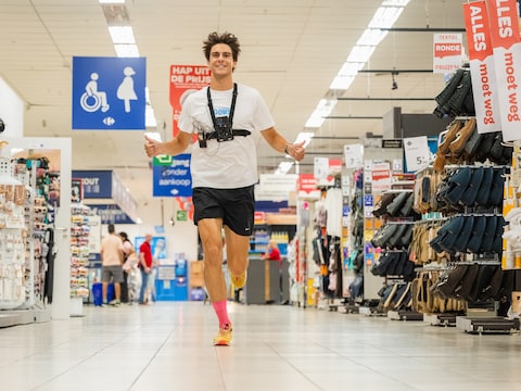 Triatleet Joren Van Dorpe vertrekt voor een unieke marathon in de Carrefour Hypermarkt van Oostakker.