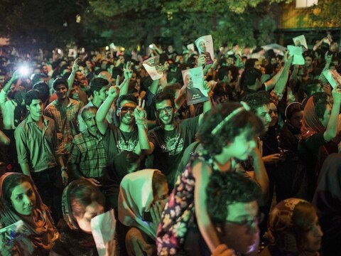 Aanhangers van Rohani vieren zijn overwinning op straat in Teheran, zaterdagavond.