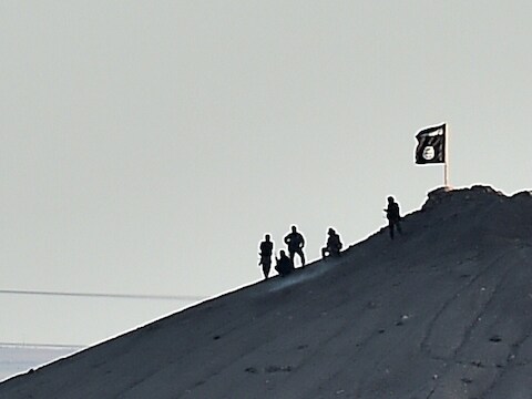In de strijd om de Noord-Syrische stad Kobane, bij de Turkse grens, heeft Islamitische Staat zijn zwarte vlag gehesen op een berg nabij de stad. Een fotograaf van het persagentschap Reuters kon dit vastleggen op camera.
