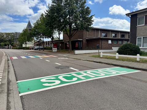 Verwijderde parkeerstroken langs de weg en groene markeringen met ‘school’ erin op de baan zorgen voor een veiligere schoolomgeving aan de Kiekeboes langs de Kerkstraat in Zoersel