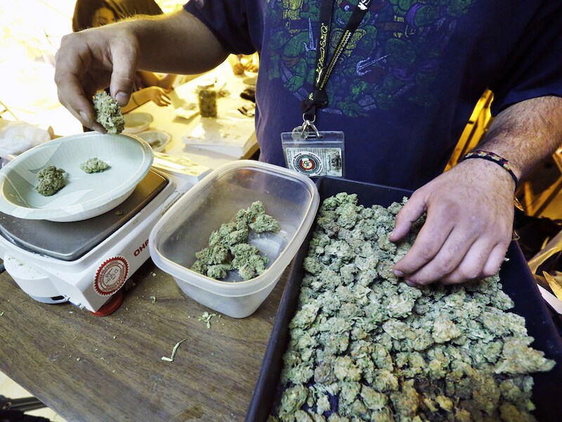 Een man verdeelt porties marihuana om op 1 januari te verkopen.