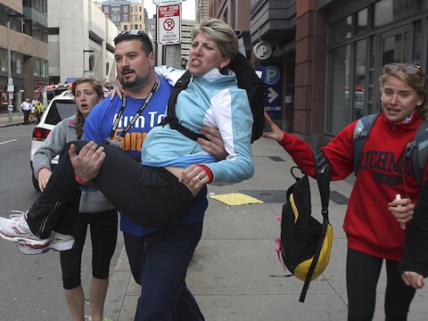 Joe Andruzzi, een voormalige speler van de New England Patriots, evacueert een gewonde vrouw.