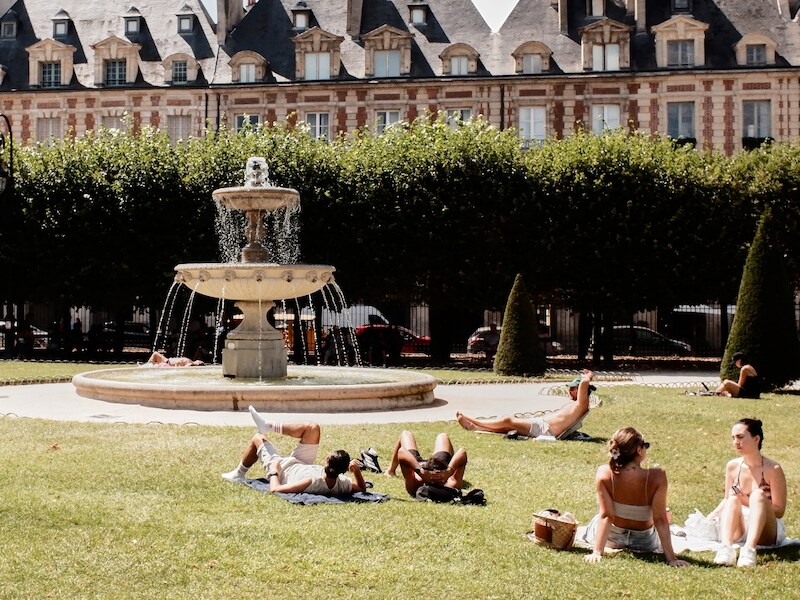 Zonnekloppers op de Place des Vosges in Parijs tijdens een hittegolf. 