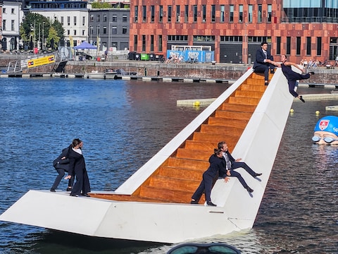 De acrobaten proberen de drijvende trap in balans te houden.