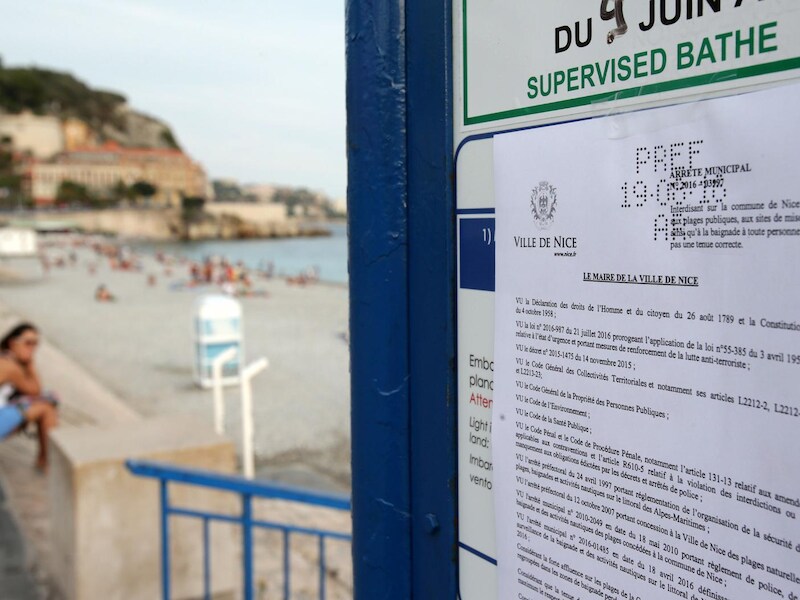 Op een bord staan de nieuwe kledingvoorschriften die gelden op het strand van Nice.
