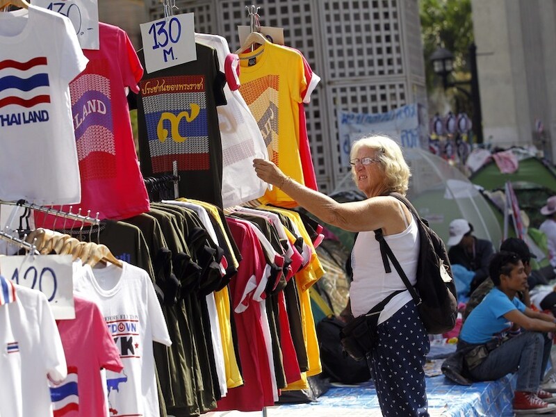 Een toerist bekijkt t-shirts met anti-regeringsslogans.