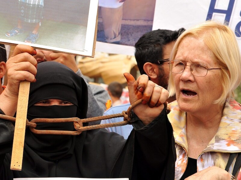 Een Amerikaanse activiste (rechts) voegt zich bij een betoging die maandag in Jemen werd gehouden voor de vrijlating van een aantal Jemenitische gevangenen in Guantánamo.
