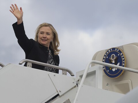 Hillary Clinton op de trappen van het vliegtuig.