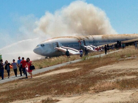 De neergestorte Boeing kort na de ramp tijdens de evacuatie. De foto is gemaakt door een van de passagiers, Eugene Anthony Rah, en ter beschikking gesteld van persbureau Reuters.
