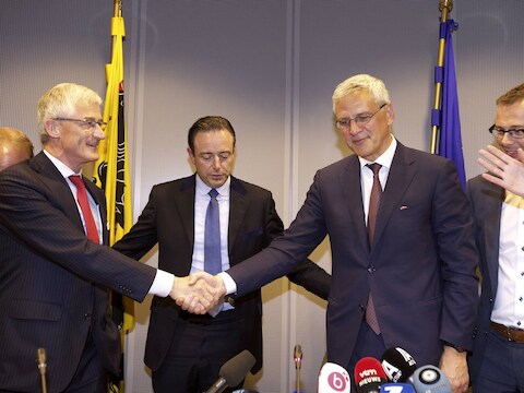 Geert Bourgeois en Kris Peeters schudden elkaar de hand onder het oog van Bart De Wever.