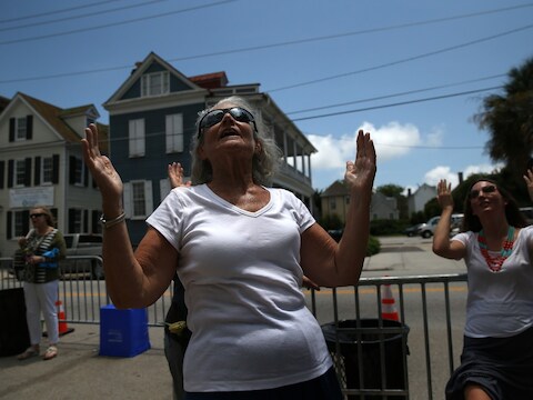 In Charleston bidden vrouwen op straat, voor de kerk waar Dyllan Roof negen mensen doodschoot.