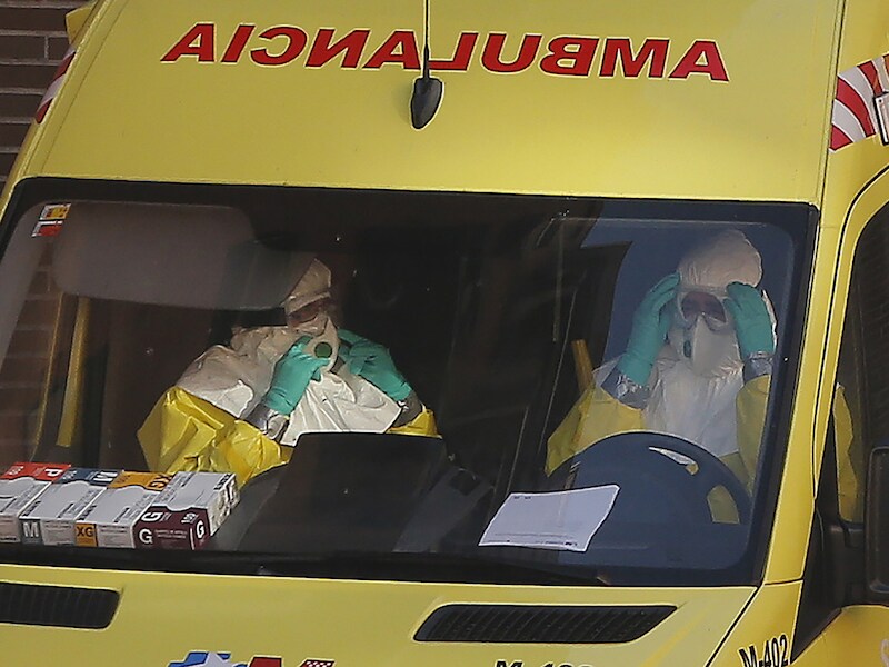Ambulanciers arriveren aan het appartement waar verpleegassistente Teresa Romero woont om het appartement te ontsmetten.