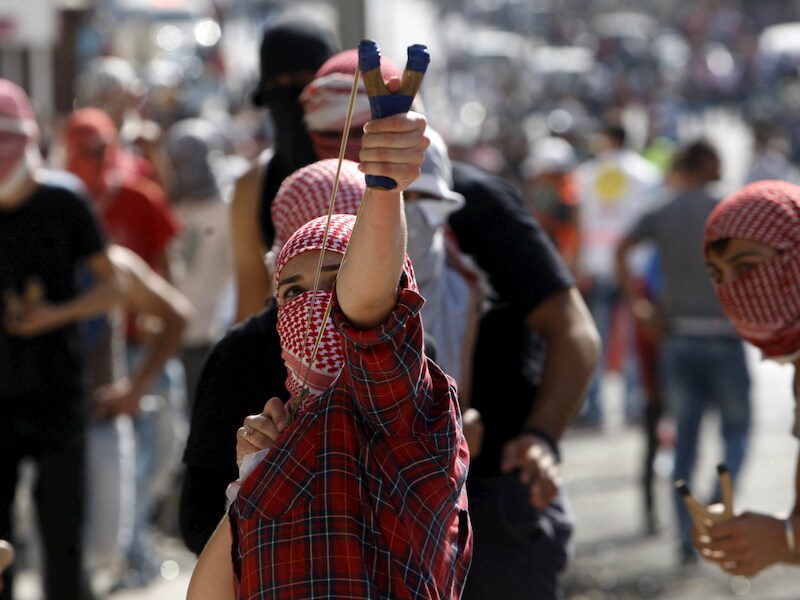 Een Palestijns meisje schiet met een katapult stenen naar Israëlische soldaten. Jaarlijks worden 500 tot 700 Palestijnse kinderen voor de militaire rechtbank in Israël gebracht.