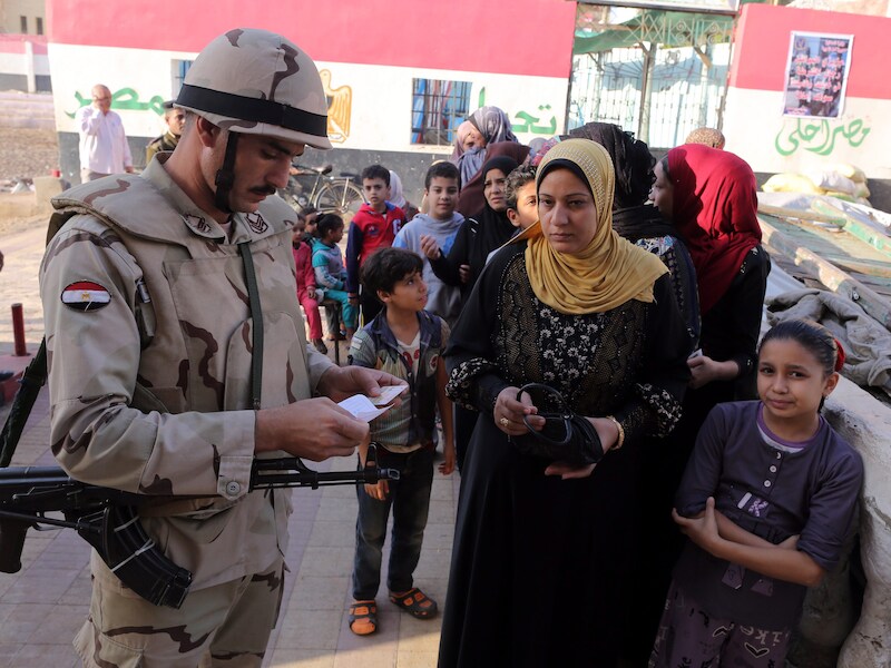 Een Egyptische soldaat checkt het id-bewijs van een kiezer.