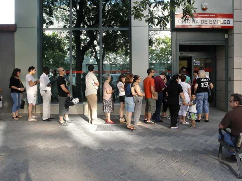 Spaanse werklozen wachten in de rij voor een arbeidsbemiddelingsbureau in Madrid.