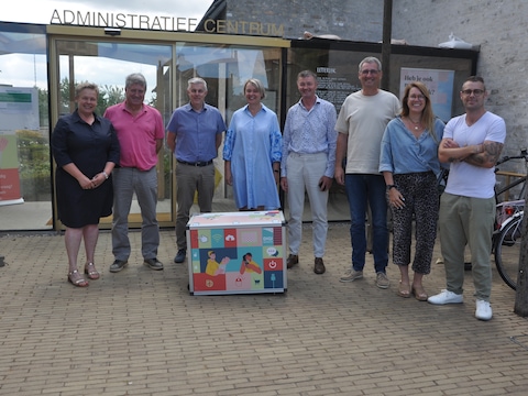 We zien Dorine Feryn, schepen Johan Matthys, algemeen directeur Geert Van Kerckhove, burgemeester Lieve Castryck, de schepenen Wout Cornette en Jan Deheegher, coördinator Mens Tiebe De Bruycker en maatschappelijk werker John Calcoen.