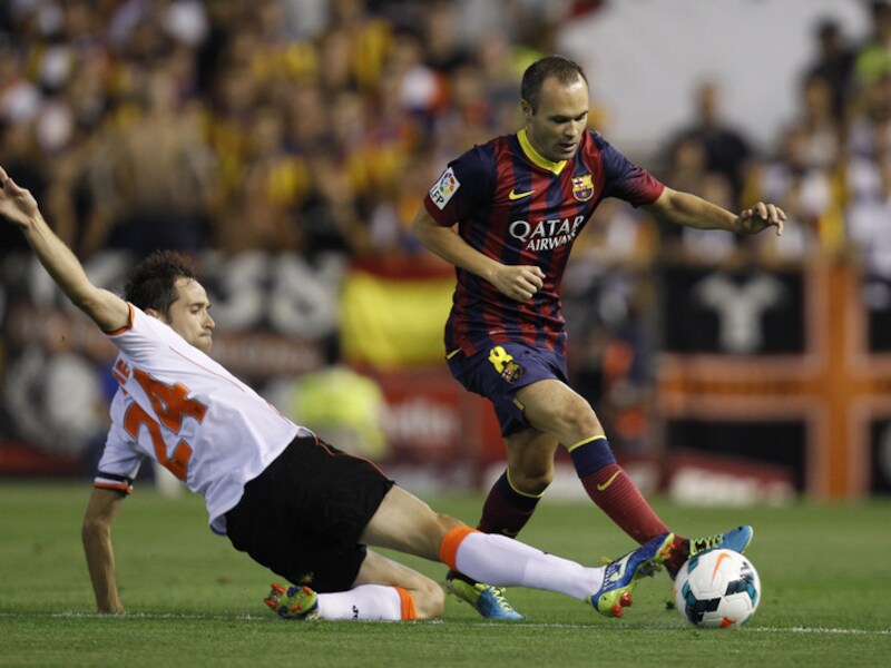 Iniesta hier in duel met Michel van Valencia