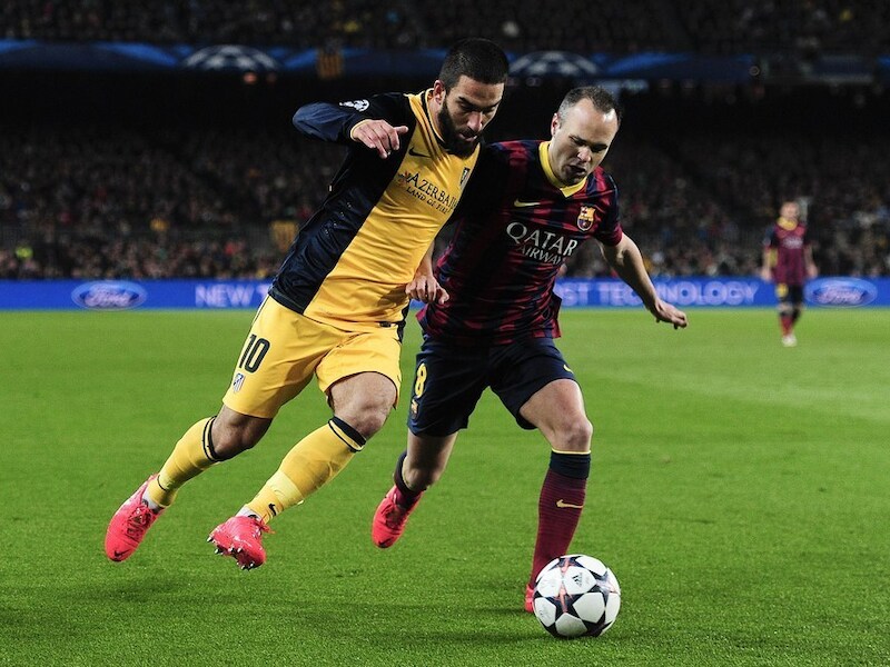 Arda Turan (links) in actie tegen Iniesta.